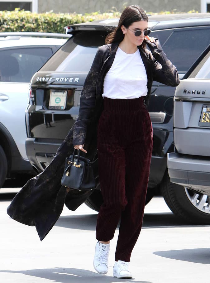 Le mannequin Kendall Jenner porte un pantalon taille haute en velours bordeaux. 